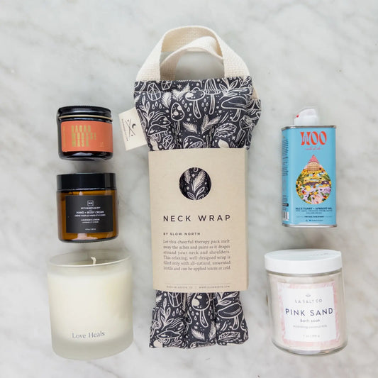 Contents of the Rest & Relaxation Gift Box including weighted neck wrap, candle, lotion, and Pink Sand bath soak