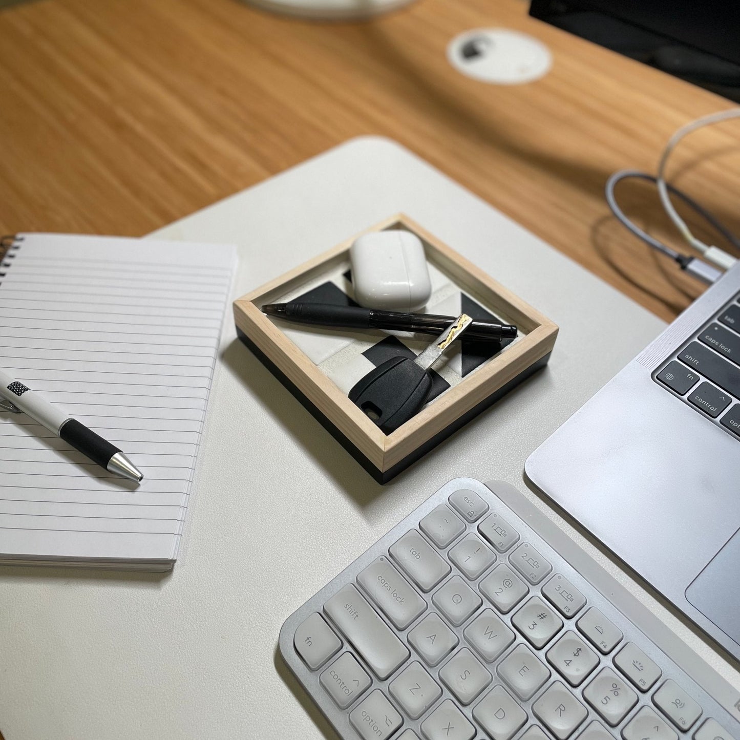 Tile Tray with key, pen, and earbuds on a desk next to computer and notepad
