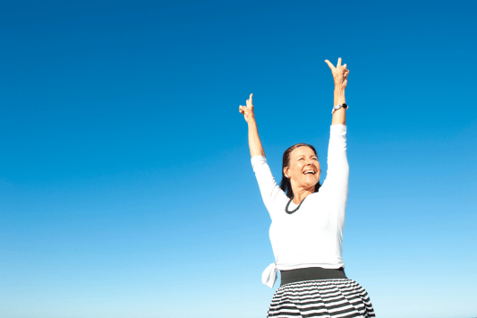 Woman with arms in the air celebrating