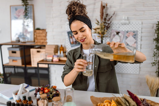 Woman mixing essential oils with carrier oils for skincare