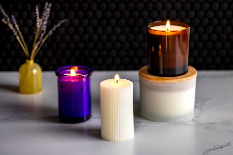 A set of burning candles on a bathroom counter