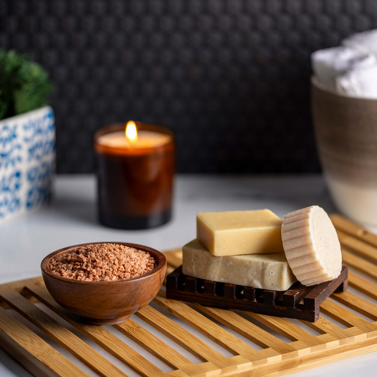 Bathroom setting with white flowers, towels, and a selection of candles