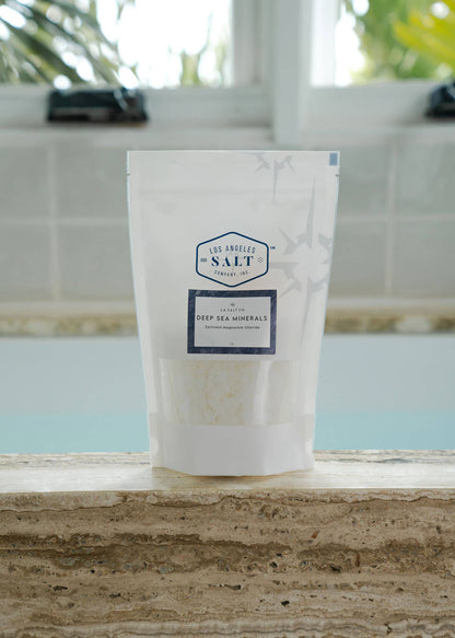 Bag of Zechstein magnesium bath flakes on a bath ledge with a blurred background. 