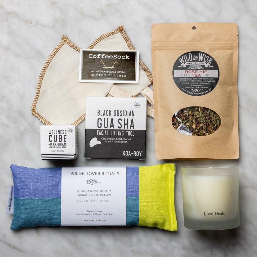 Eye pillow, candle, tea and filters, gua sha, and a wellness cube