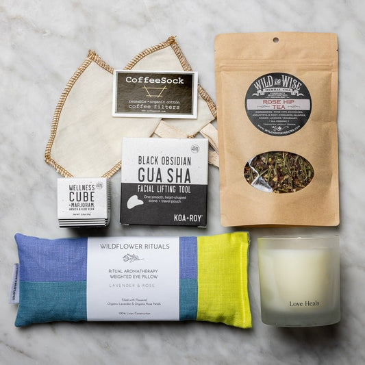 Eye pillow, candle, tea and filters, gua sha, and a wellness cube