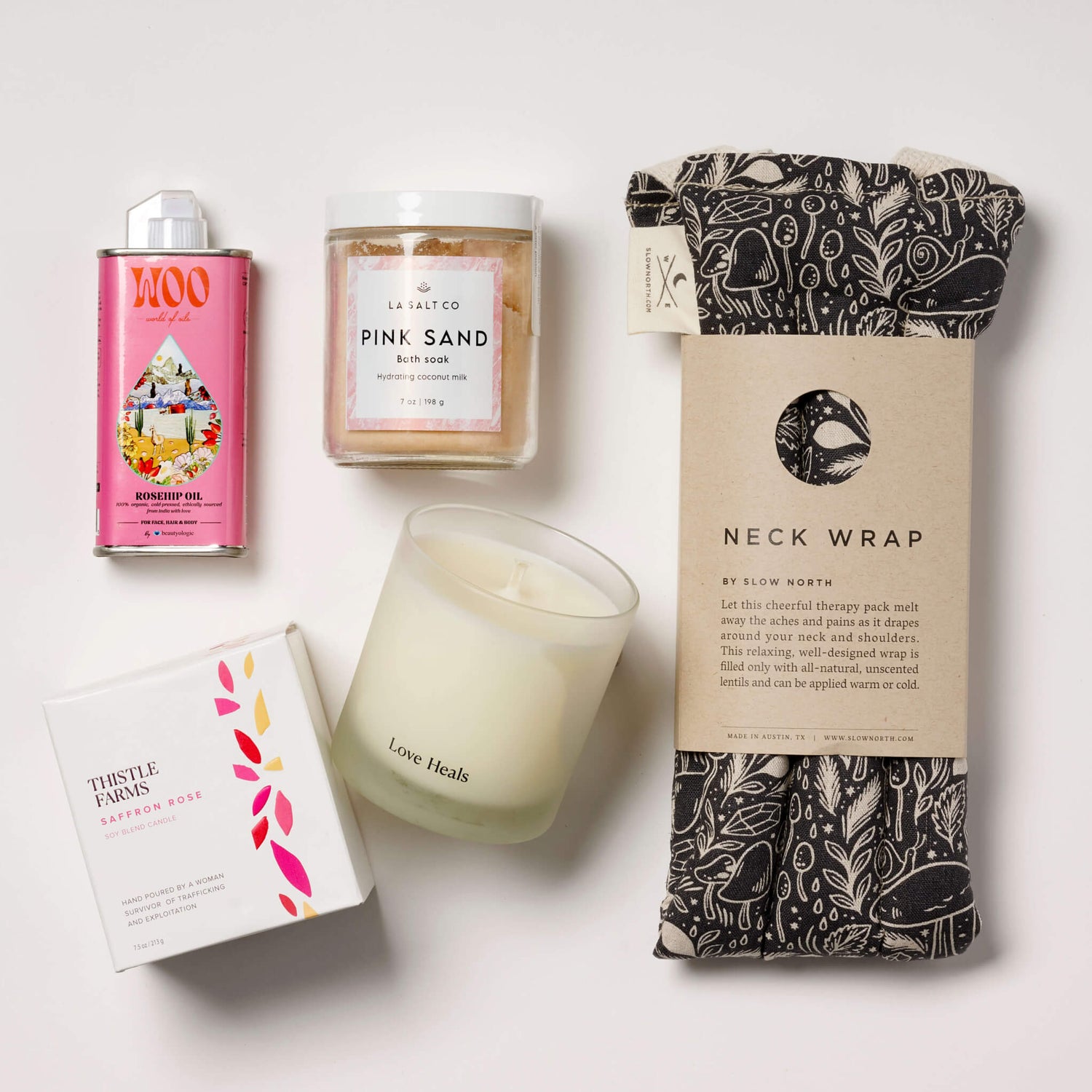 Overhead photo of the contents of the Melt Gift Box for rest and relaxation including weighted neck wrap, candle, oil, and Pink Sand bath soak