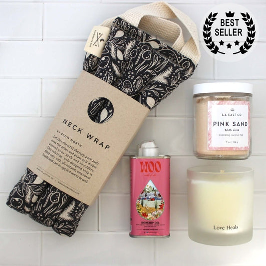 Overhead photo of the contents of the Melt Gift Box for rest and relaxation including weighted neck wrap, candle, oil, and Pink Sand bath soak