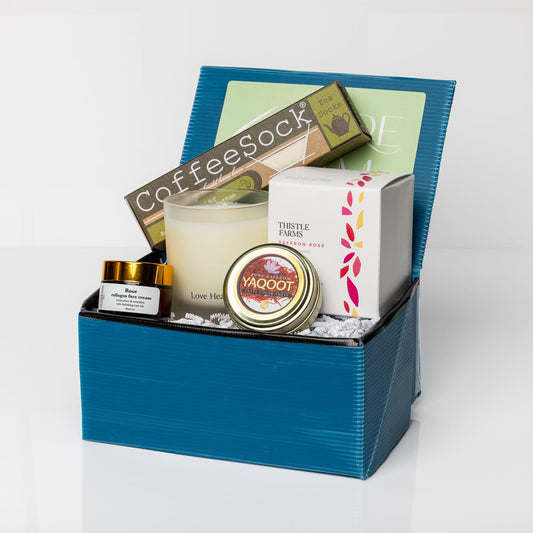 Blue gift box with collagen face cream, organic saffron, saffron rose soy candle, and reusable tea filters.