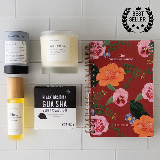 Stress relief gifts with journal, candle, tea, gua sha and body oil. 