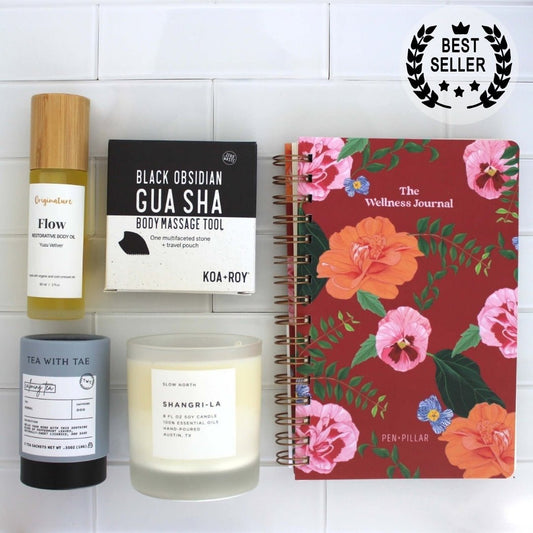 Stress relief gifts with journal, candle, tea, gua sha and body oil. 