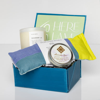 Blue box with Lavender Chai Organic Lotion Bar, Lavender & Roses Eye Pillow, and Shangri-La Frosted Candle.