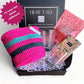 Gift box packed with home goods and treats: basket, bar glasses, dried cherries, notepad