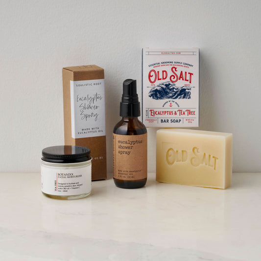 Collection of Eucalyptus and Tea Tree products including a bar soap, facial moisturizer, and shower spray on a white background.