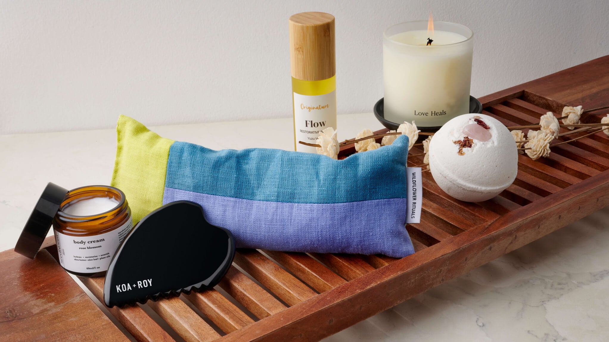 Ethically made self-care products from women-owned brands on a tray over a bath tub.