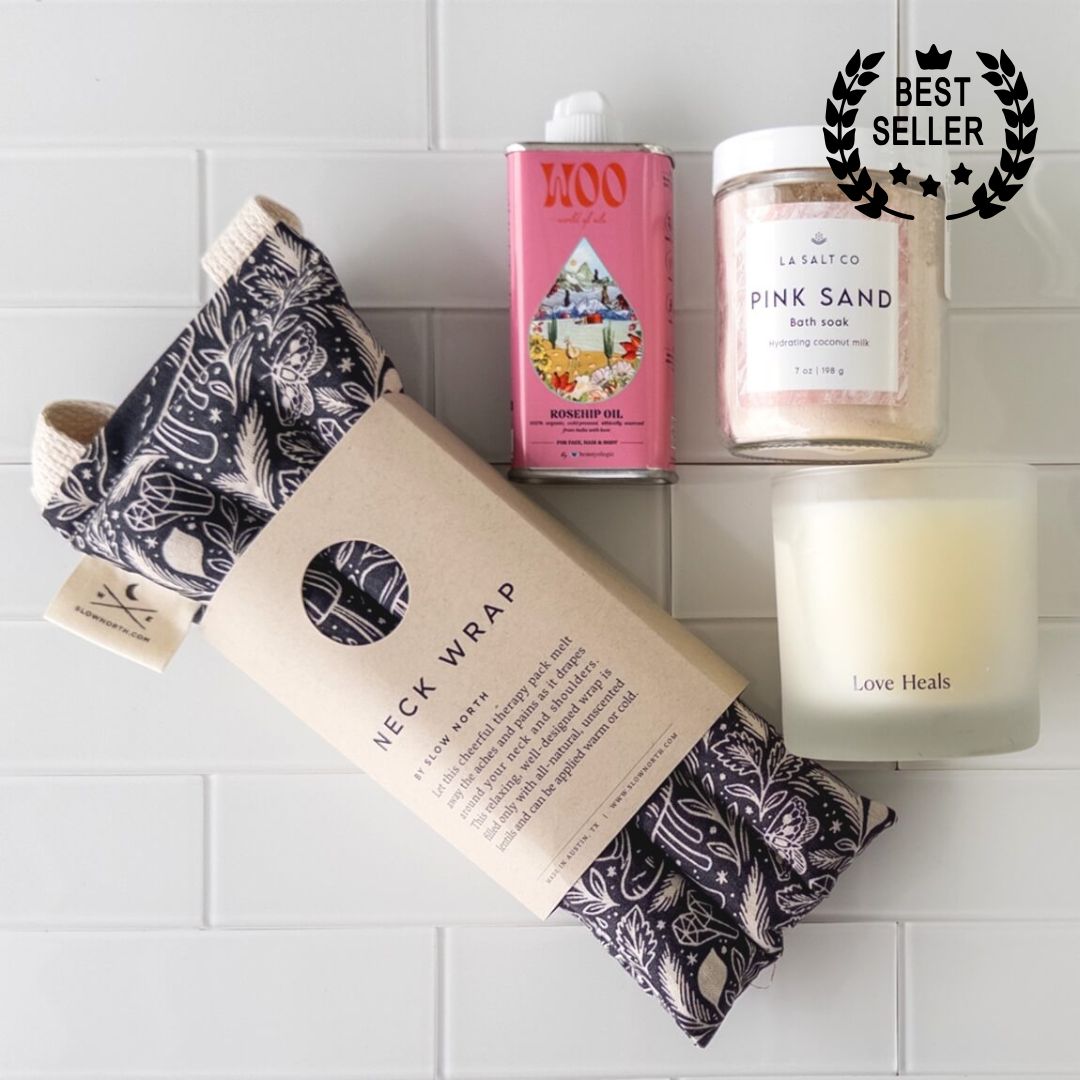 Overhead photo of the contents of the Melt Gift Box for rest and relaxation including weighted neck wrap, candle, oil, and Pink Sand bath soak