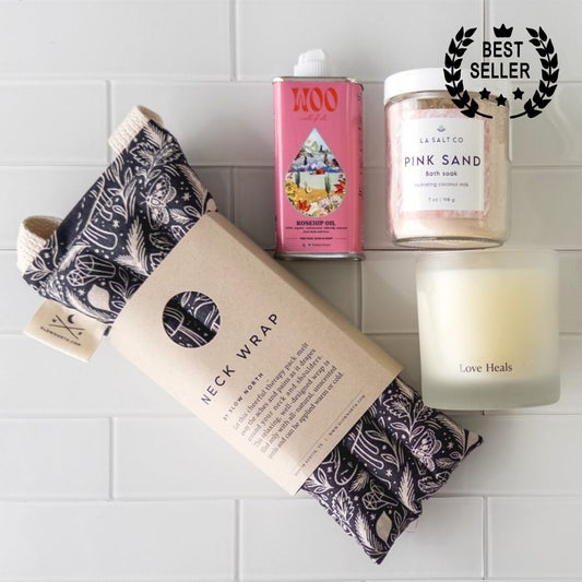 Overhead photo of the contents of the Melt Gift Box for rest and relaxation including weighted neck wrap, candle, oil, and Pink Sand bath soak
