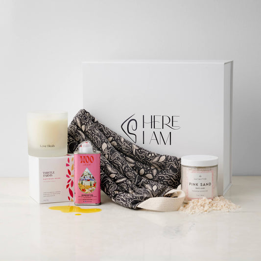 Contents of the Melt Box including weighted neck wrap, candle, oil, and Pink Sand bath soak with the premium gift box in background