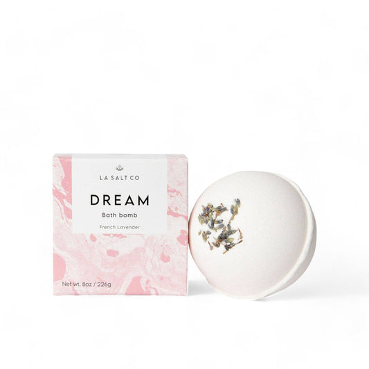 The Dream Bath Bomb next to the pink box it comes in on a white background