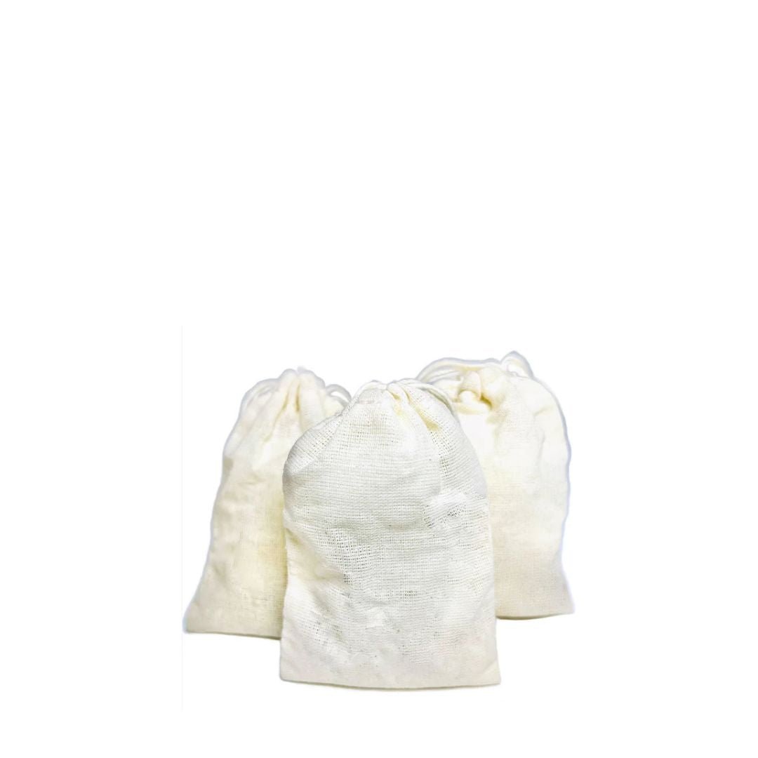 Three white drawstring sachets of the Queen of Flowers Milk Bath on a white background