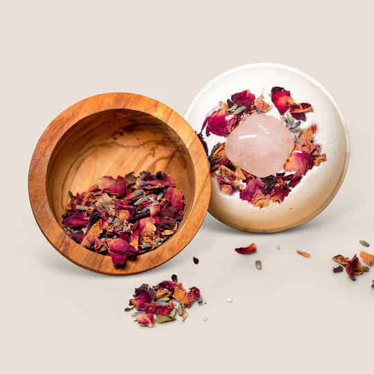 Rose Bath Bomb with wooden bowl filled with dried flowers and petals on a beige background