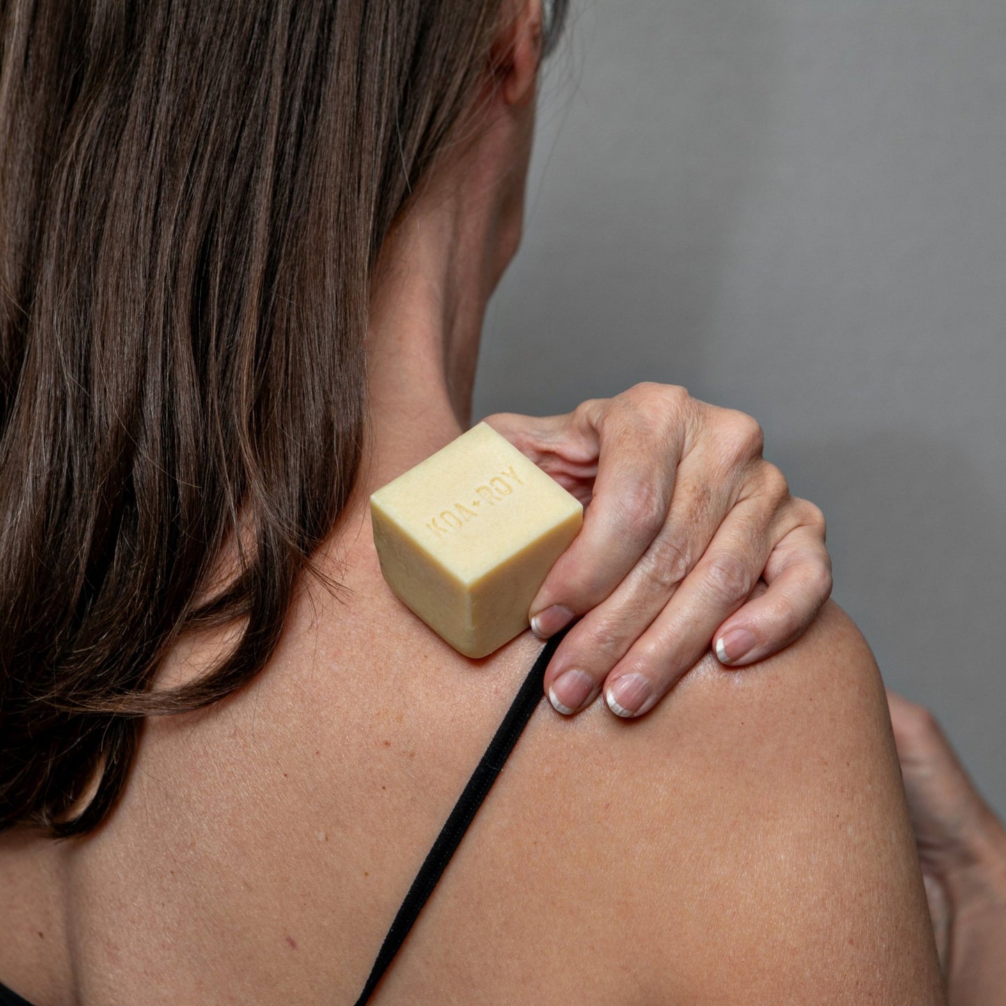 Wellness cube being applied to the back of a woman