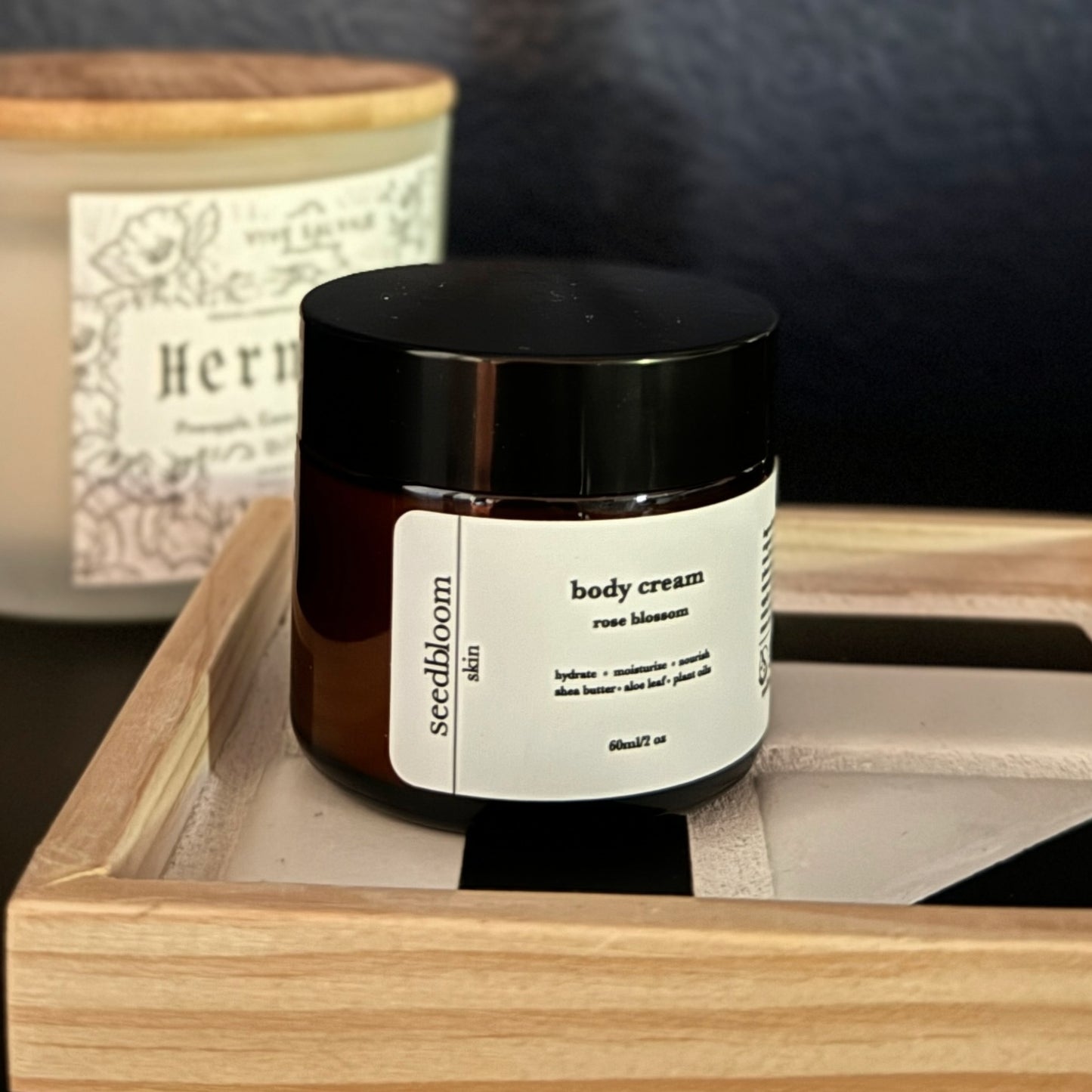 The seedbloom body lotion on the tile tray with the candle in the background