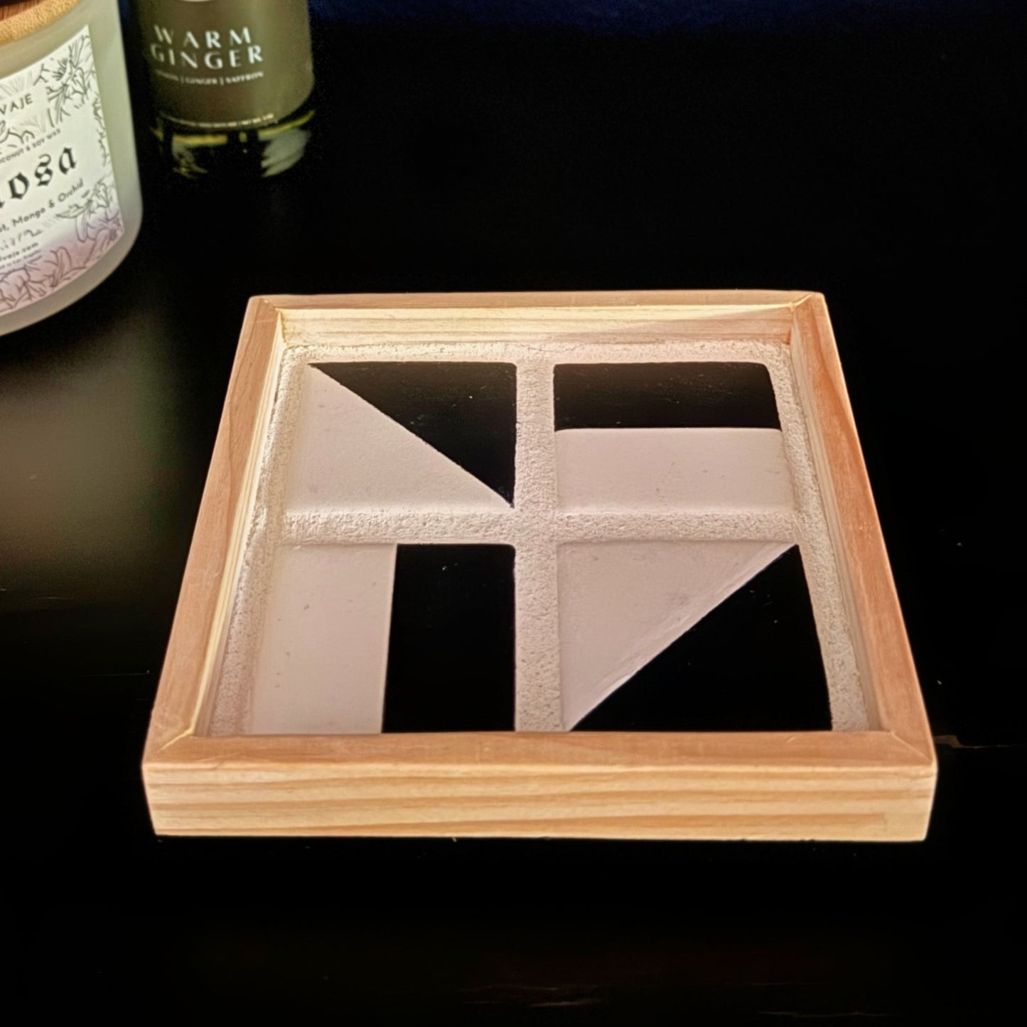 The black and white tile tray with candle and diffuser in the background