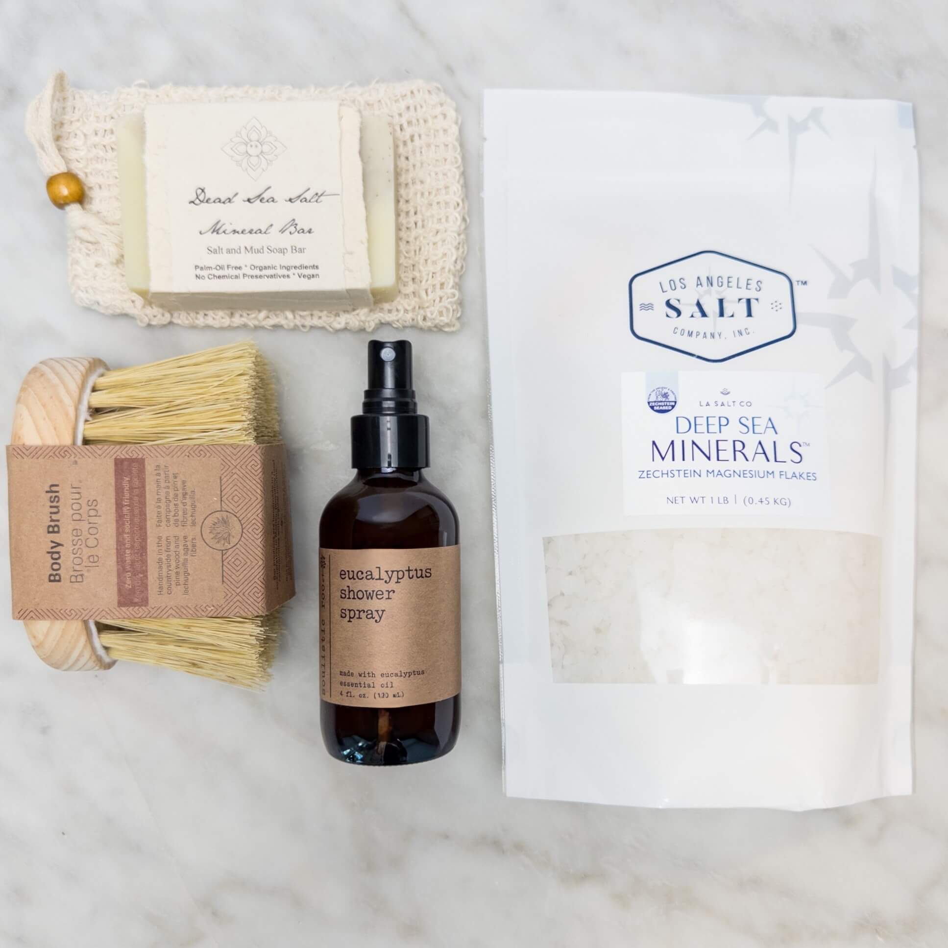 Contents from the Magnesium Bath Box, including Zechstein sea salts, body brush, shower spray, and soap.