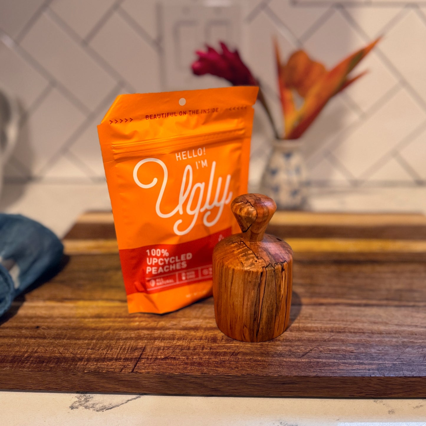 Bag of Upcycled Dried Peaches from the Ugly Company with the biscuit cutter on a wooden board