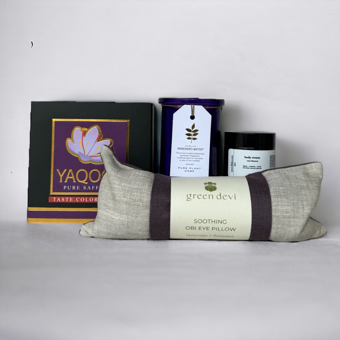 Selections from the Rejuvenation Box: eye pillow, lavender candle, body lotion, and saffron on white background
