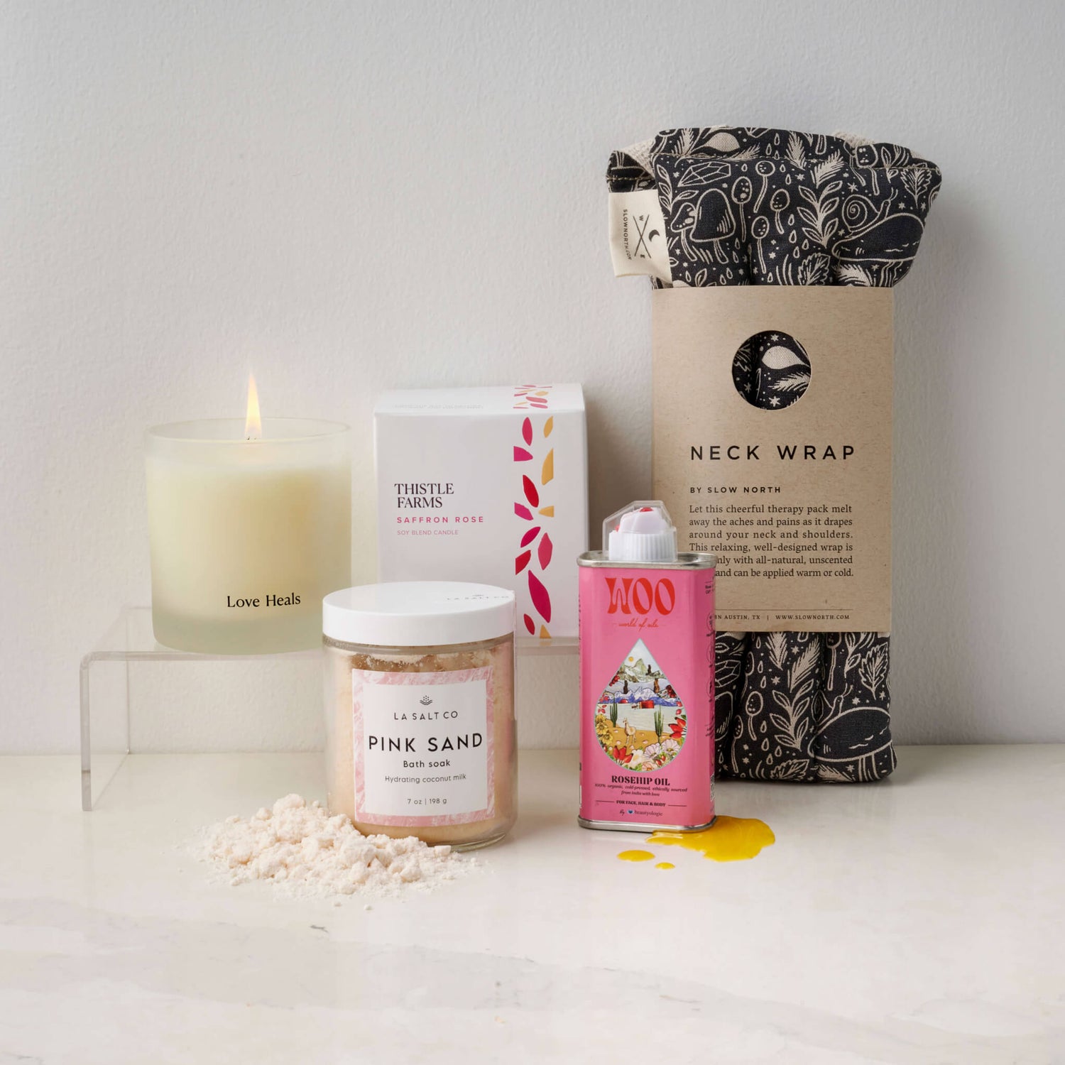 Contents of the Melt Gift Box including weighted neck wrap, candle, oil, and Pink Sand bath soak