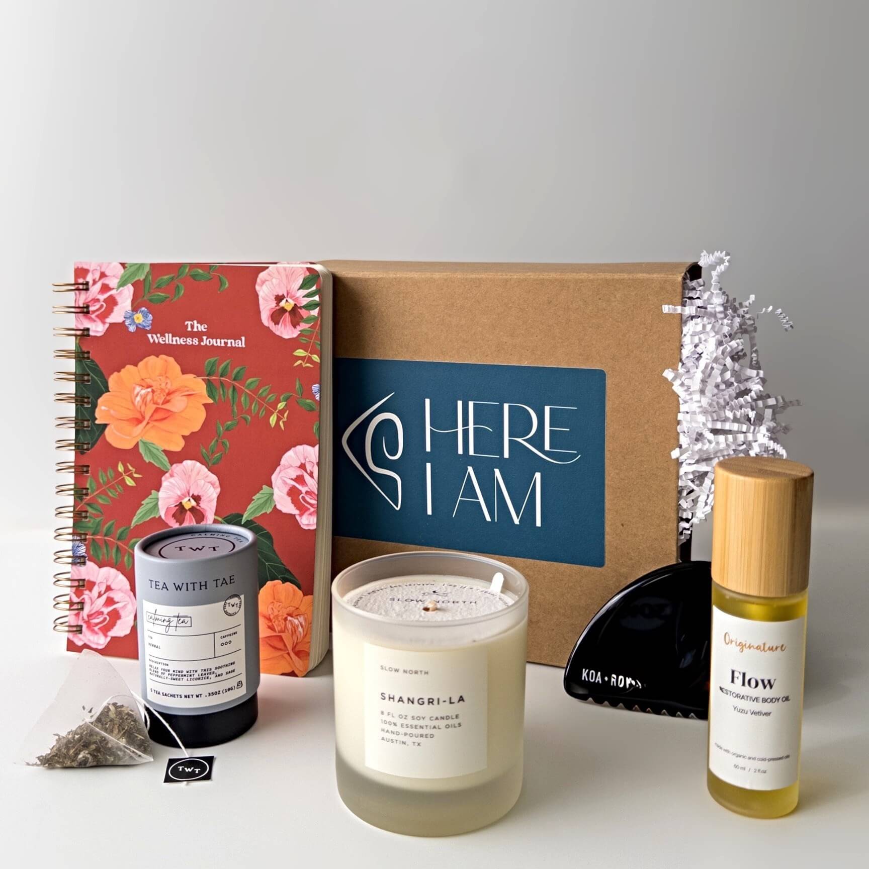 Stress relief gift box contents with journal, candle, tea, gua sha and body oil. 