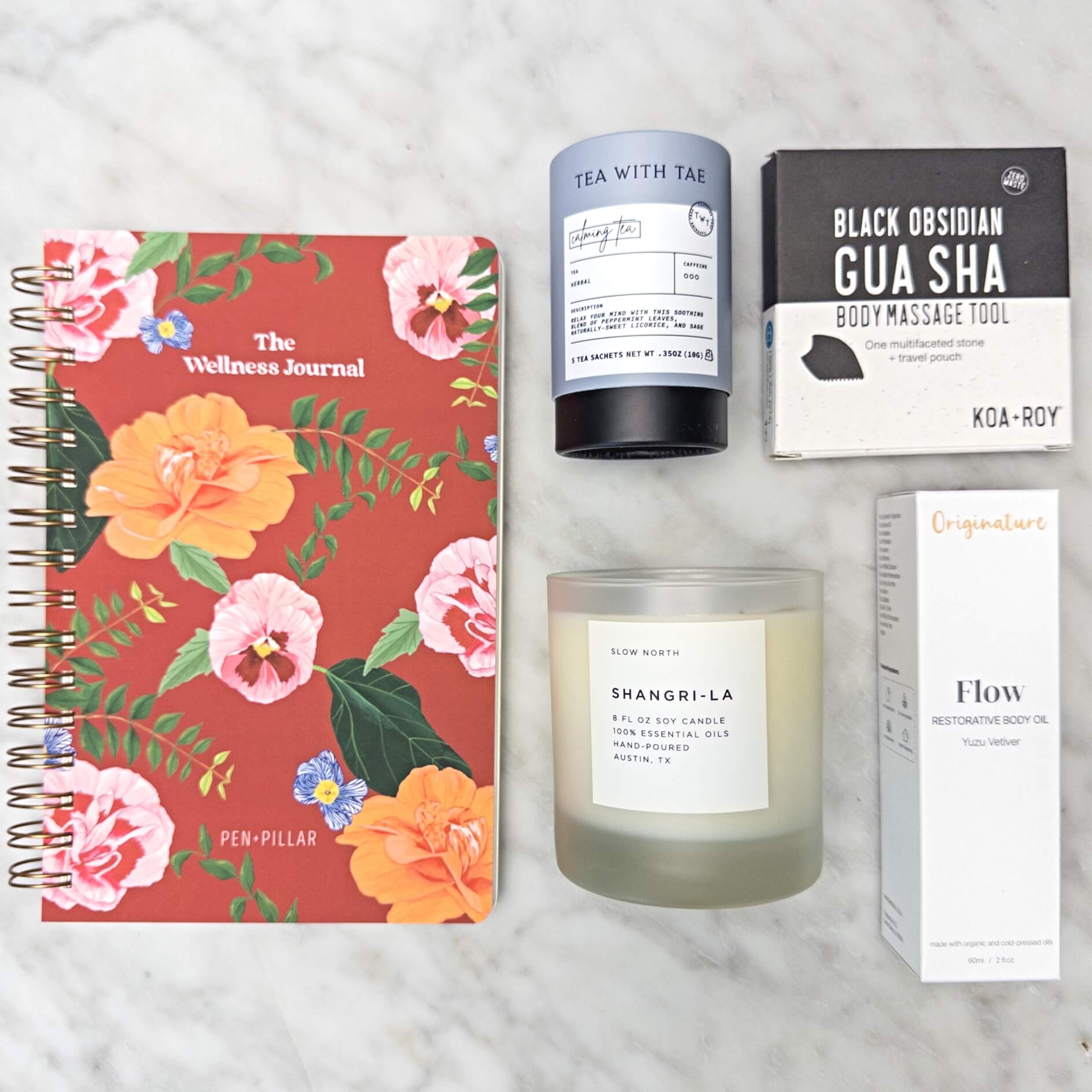 Stress relief gifts with journal, candle, tea, gua sha and body oil. 