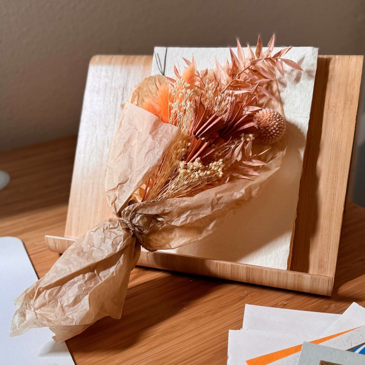 Dried flower bouquet in cream and coral tones wrapped in tissue