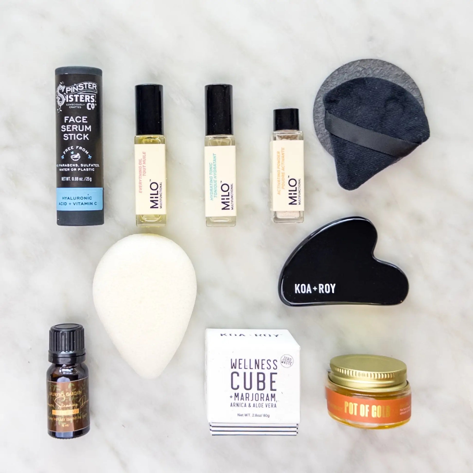 Collection of skincare and wellness products from the travel skin care kit on a light background