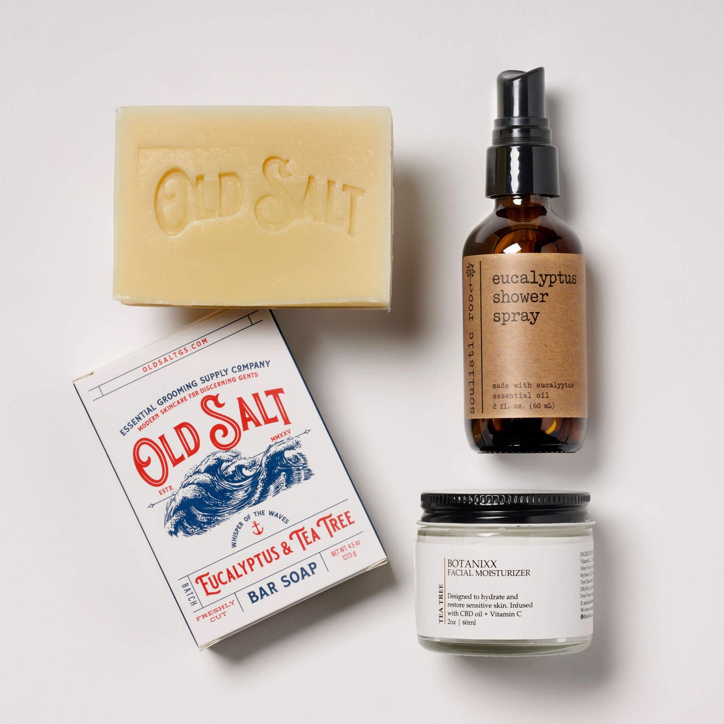Collection of Eucalyptus and Tea Tree products including a bar soap, facial moisturizer, and shower spray on a white background.