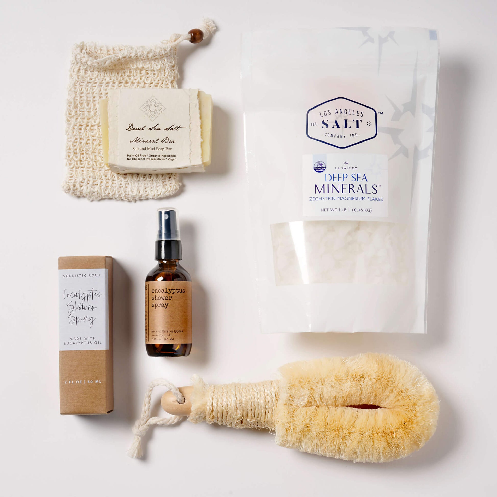 Contents from the Magnesium Box, including Zechstein sea salts, a natural fiber body brush, eucalyptus shower spray, and dead sea salt soap.