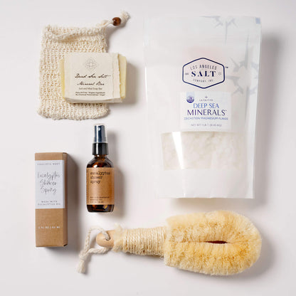 Contents from the Magnesium Box, including Zechstein sea salts, a natural fiber body brush, eucalyptus shower spray, and dead sea salt soap.