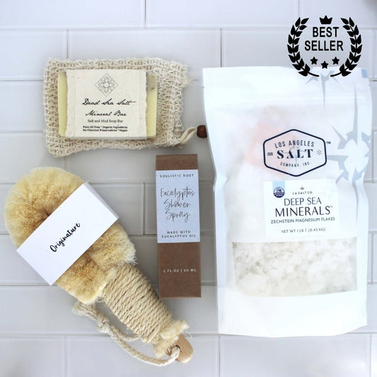 Contents from the Magnesium Scrub Box, including Zechstein sea salts, a natural fiber body brush, eucalyptus shower spray, and dead sea salt soap.