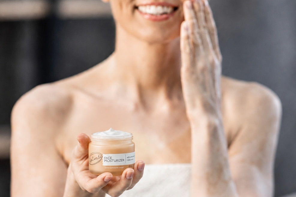 Woman applying face moisturizer to her skin