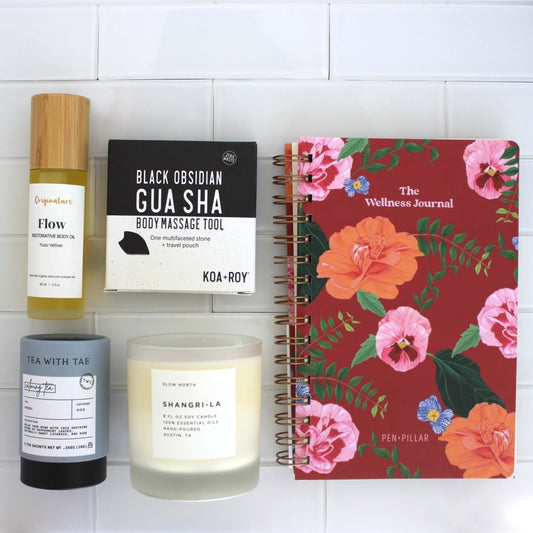 Stress relief gifts with journal, candle, tea, gua sha and body oil. 