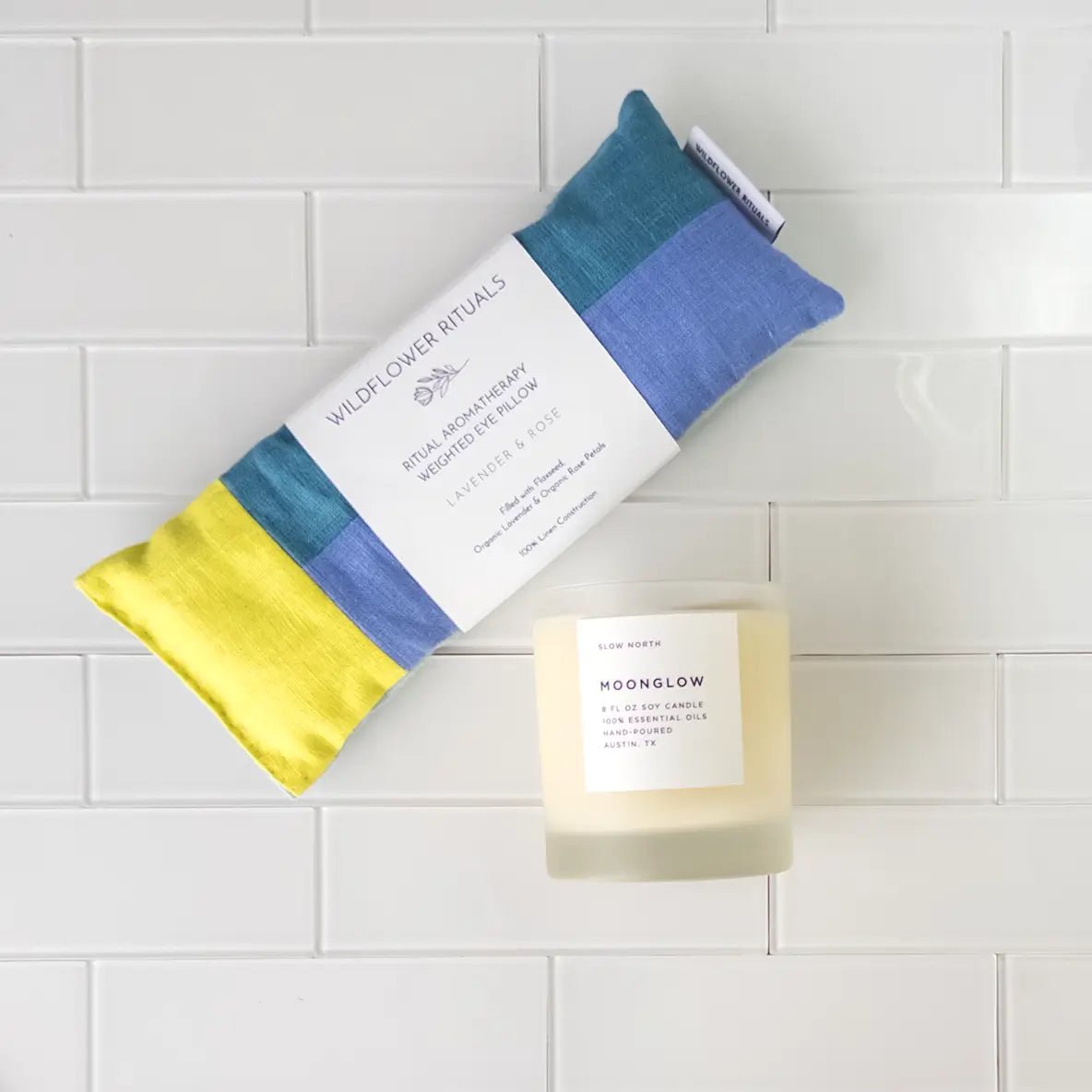 Items from the Unwinding Box, including the Moonglow Essential Oil Candle and Lavender & Rose eye pillow