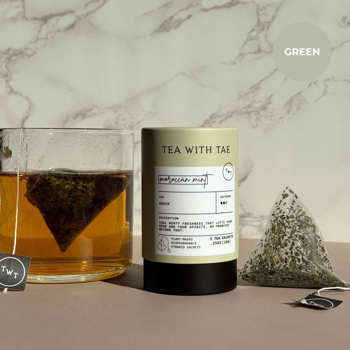 Tea packaging with a glass of tea and tea bag on a marble background