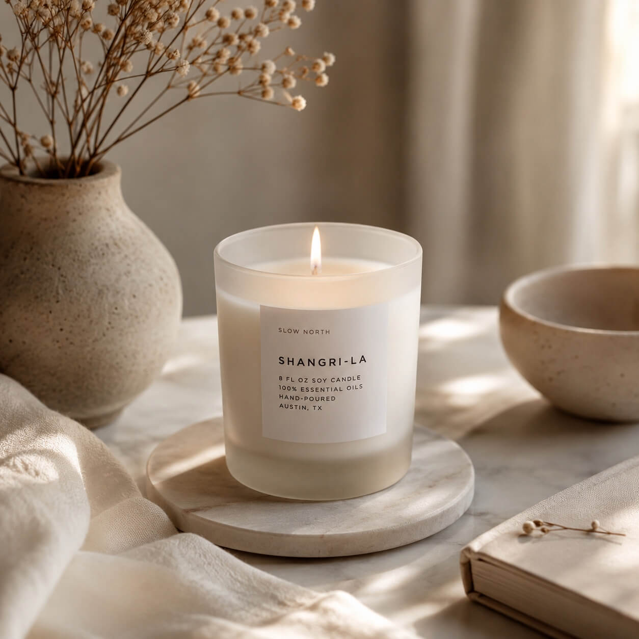 Shangri-La soy wax candle on a stone coaster with decorative elements in the background.