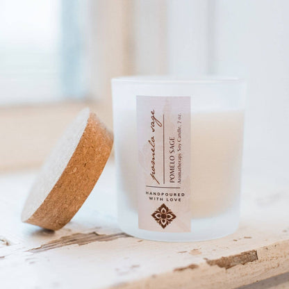 The Pomelo Sage candle on a window sill with the cork top next to it