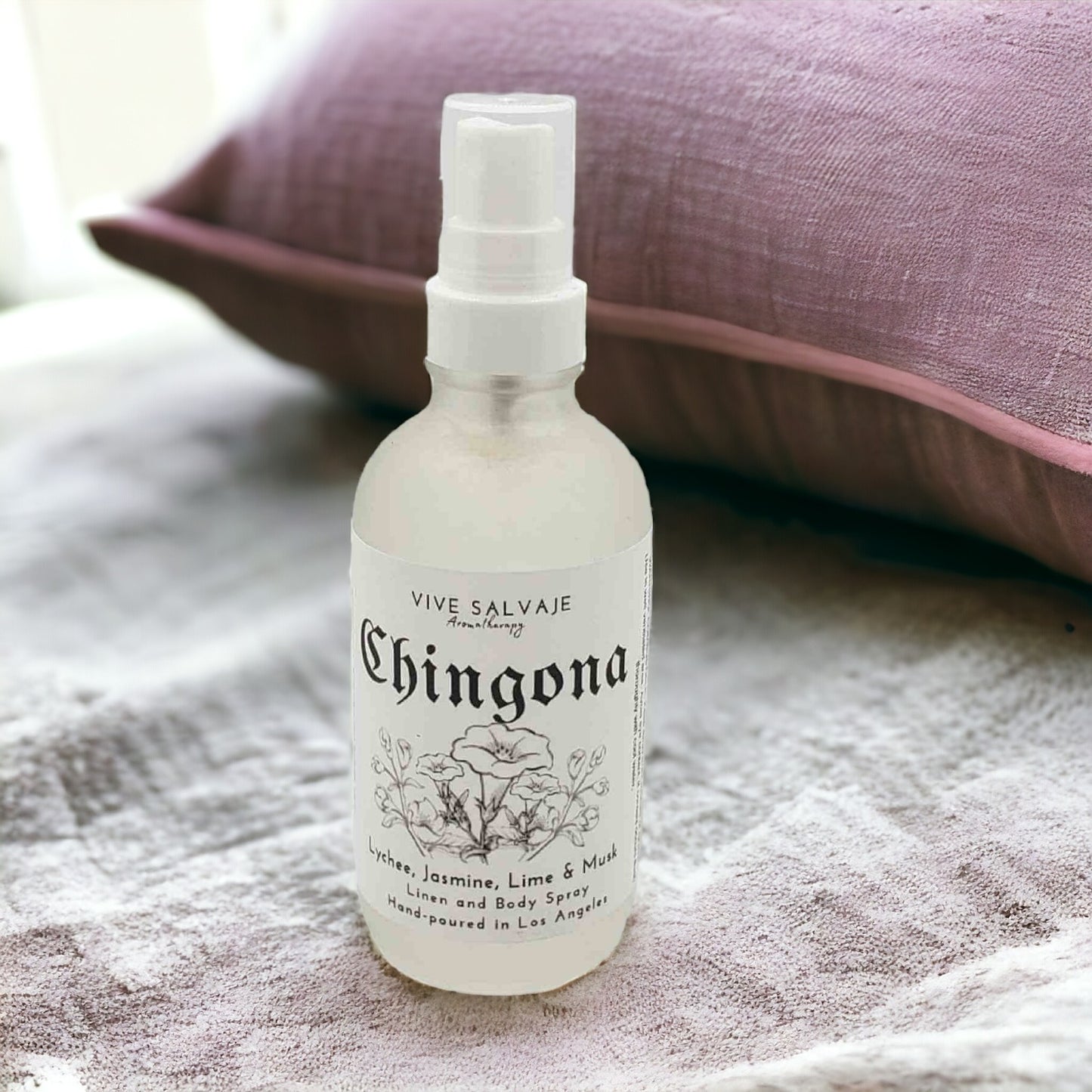 Chingona Room & Linen Spray on linen with a plum pillow