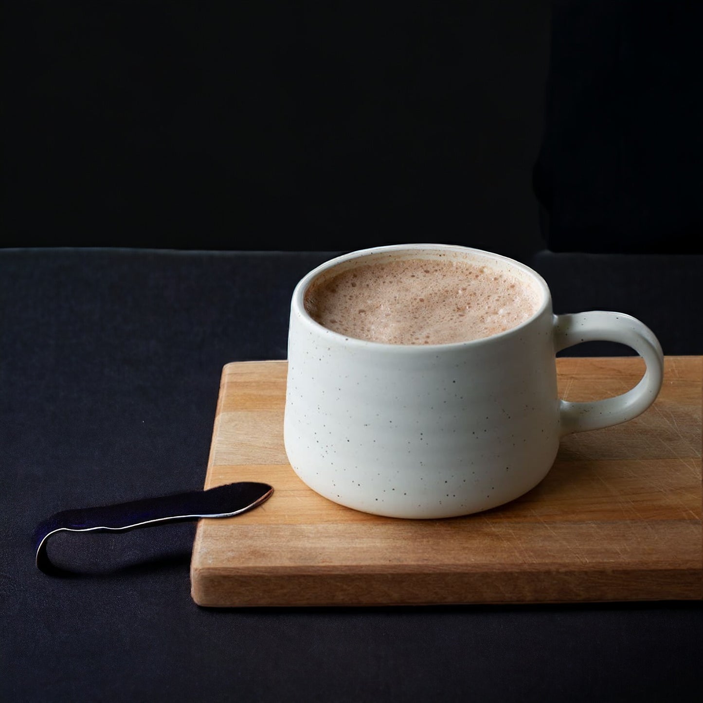 Mug of hot cacao on a small cutting board