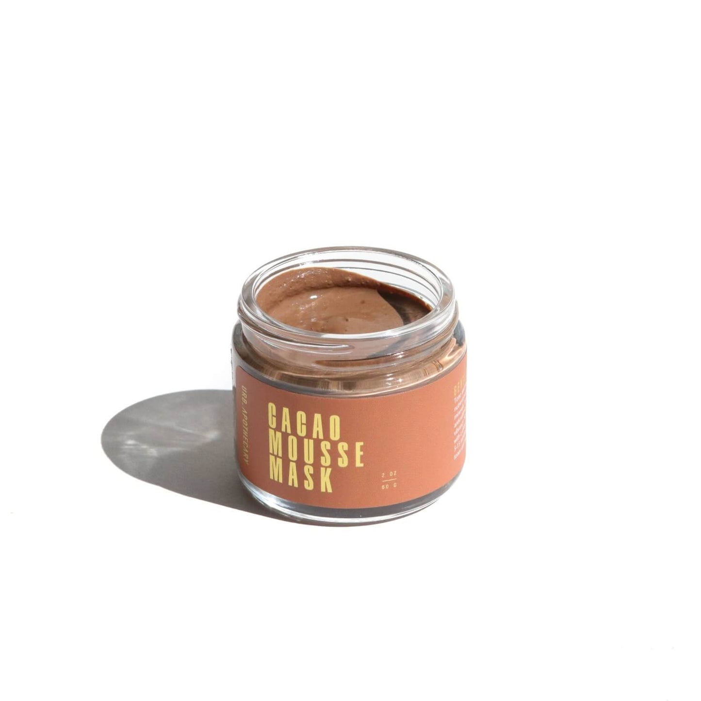 Open jar of the Cacao Mousse Mask on a white background with shadows