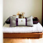 The Green Devi linen eye pillow on a white towel next to a tray of spa accessories