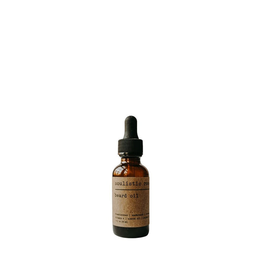Brown glass bottle with dropper labeled Soulistic Root Beard Oil on a white background